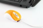 Orange Computer Mouse On Working Desktop Stock Photo