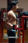 Young Man Doing Heavy Weight Exercise In Gym Stock Photo