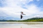 Happy Asian Woman Jumping Fun On The Beach Stock Photo