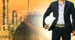 Engineering Man And Safety Helmet Standing Against Oil Refinery Stock Photo