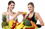 Young Smiling Girls Each Holding Glass Of Juice Stock Photo