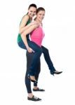 Teenage Girl Piggybacks Her Friend Stock Photo