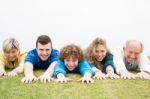 Happy Family Lying On Green Lawn Stock Photo