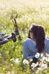 Young Woman With Mountain Bike Stretched On The Field Stock Photo