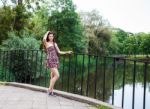 Beautiful Brunette Standing On The Bridge Near The River Stock Photo