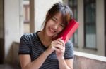 Portrait Of Thai Adult Beautiful Girl Reading Red Book Stock Photo