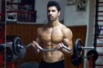 Young Man Doing Heavy Weight Exercise In Gym Stock Photo