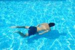 Young Man Swimming Underwater Stock Photo