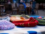 Wooly Beanies On A Table With People In The Background Stock Photo