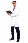 Full Length Shot Of Physician Posing With Clipboard Stock Photo