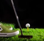 Green Shoe And Golf Ball On Field Stock Photo