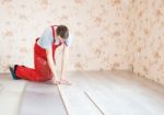 Handyman Laying Down Laminate Flooring Boards Stock Photo