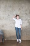 Attractive Teenage Asian Girl Standing In Front Of Grunge Concrete Wall Stock Photo