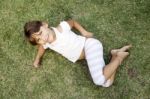 Young Cute Girl Lying On The Grass Stock Photo