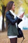 Beautiful Girl Chatting With Mobile Phone In Autumn Stock Photo