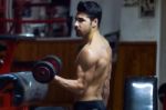 Young Man Doing Heavy Weight Exercise In Gym Stock Photo