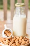 Bottle Of Almond Milk On Wooden Table Stock Photo