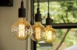 Glowing Retro Light Bulbs Hanging From Ceiling Stock Photo