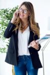 Business Young Woman Using Her Mobile Phone In The Office Stock Photo