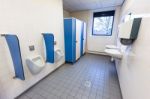 Toilet Room For Men With Urinals Sinks And Towel Dispenser Stock Photo