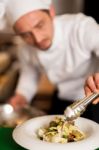 Chef Arranging Tossed Salad In A White Bowl Stock Photo