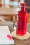 Red Syrup In The Bottle On Wooden Plate Stock Photo