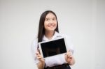 Portrait Of Thai High School Student Uniform Beautiful Girl Using Her Tablet Stock Photo