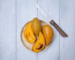 Yellow Fruit On Wooden Plate Stock Photo