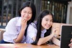 Two Asia Thai High School Student Uniform Best Friends Beautiful Girl Using Her Tablet And Funny Stock Photo