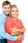 Happy Man Embracing His Wife From Behind Stock Photo