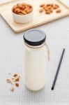 Almond Milk In Bottle With Almonds On Table Stock Photo