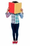 School Girl Hiding Her Face With A Book Stock Photo