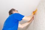 Worker In Protective Gloves With Spatula Smoothing Wallpaper Stock Photo