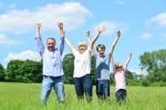 Happy Family Together Raising Their Arms Stock Photo