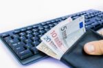 Hand Holding Wallet With Money At Keyboard Stock Photo