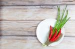 Red Hot Chilli Pepper And Green Onion On Plate Stock Photo