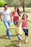 Family Playing In The Green Field Stock Photo