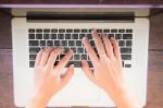 Typing On Keyboard Laptop Top View Of Wooden Table Stock Photo