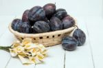 Tasty Purple Plums Isolated On A White Wooden Background Stock Photo