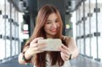 Portrait Of Thai Adult Beautiful Girl Using Her Smart Phone Selfie Stock Photo