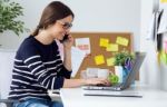 Confident Young Woman Working In Her Office With Laptop Stock Photo