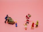 Miniature Santa Claus, A Man With Trolly And Children On Pink Ba Stock Photo