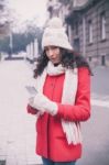 Beautiful Woman In Red Coat And Wool Cap And Gloves With Smartph Stock Photo