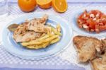 Turkey Steak With French Fries And Tomato Salad Stock Photo