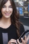 Young Woman Holding A Tablet On The Street Stock Photo