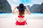 Young Woman In Red Bikini Sitting On The Beach Stock Photo