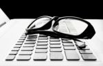 Laptop Or Notebook Button And Black Glasses  On Black Background Stock Photo