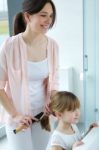 Mother Combing Her Daughter In The Bathroom Stock Photo