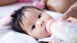 Pretty Baby Girl Is Drinking Milk Stock Photo