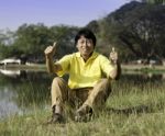 Senior Man With Thumb Up Against A Green Park Stock Photo